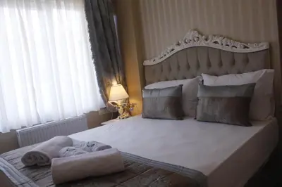 a bedroom with a large bed with a large headboard at Divani Ali Hotel in Istanbul