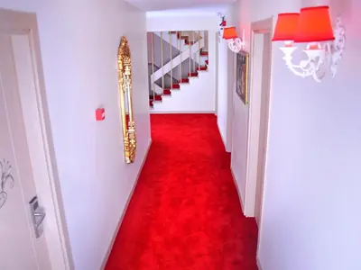 a red carpeted hallway with a red floor and stairs at Divani Ali Hotel in Istanbul