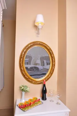 a mirror on a wall next to a table with wine glasses at Divani Ali Hotel in Istanbul