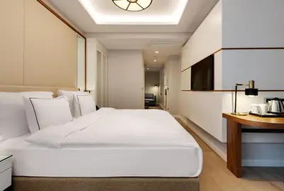 a bedroom with a large white bed and a desk at Gleam Collection Hotel in Istanbul