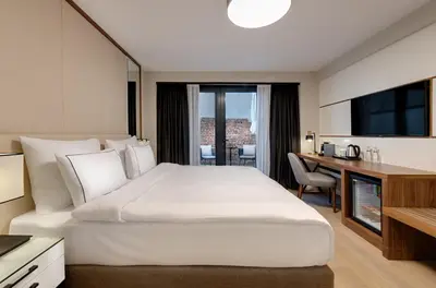 a bedroom with a large white bed and a desk at Gleam Collection Hotel in Istanbul