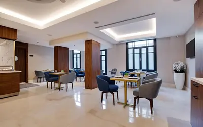 a dining room with tables and chairs and windows at Gleam Collection Hotel in Istanbul