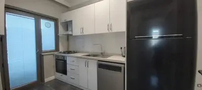 a kitchen with a black refrigerator and white cabinets at GANİGAR alibeyköy in Istanbul
