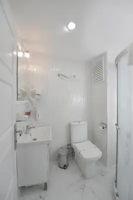 a white bathroom with a toilet and a sink at Sayeban Gold Hotel in Istanbul