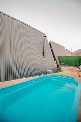 a large blue swimming pool next to a building at KARMATTE BUNGALOW in Kartepe