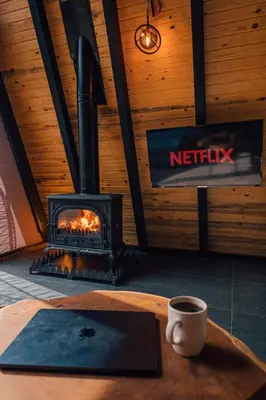 a fireplace in a room with a table with a cup of coffee at KARMATTE BUNGALOW in Kartepe