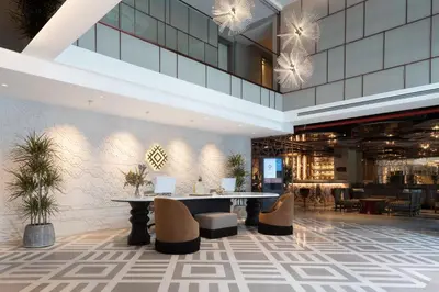 a lobby with a table and chairs in a building at Burdock Hotel Istanbul, Autograph Collection in Istanbul