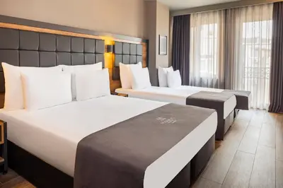 a hotel room with two beds and windows at Marius Hotel in Istanbul
