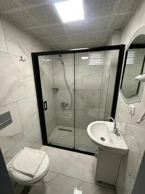 a bathroom with a shower and a toilet and a sink at Grand Kybele Hotel in Istanbul