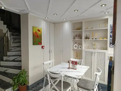 a white dining room with a table and chairs at Grand Kybele Hotel in Istanbul