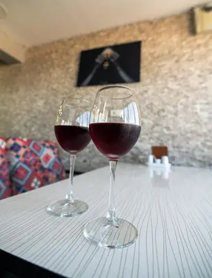 two glasses of red wine sitting on a table at Airport Black Sea Hotel & Restaurant in Arnavutköy