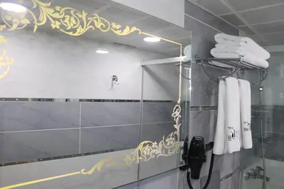a bathroom with a shower and white towels at Hotel Black Pearl in Istanbul