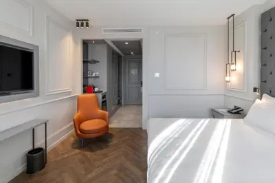 a bedroom with a bed and a orange chair at Wish More Hotel Şişli in Istanbul