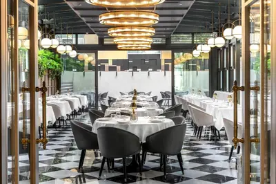 a restaurant with white tables and chairs and chandeliers at Wish More Hotel Şişli in Istanbul