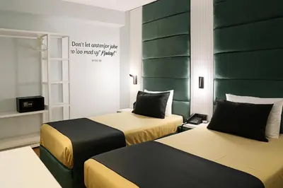 two beds in a room with green headboards at AXU AIRPORT HOTEL in Arnavutköy
