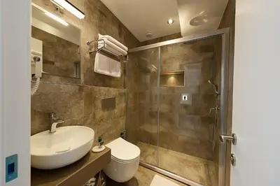 a bathroom with a toilet sink and a shower at AXU AIRPORT HOTEL in Arnavutköy