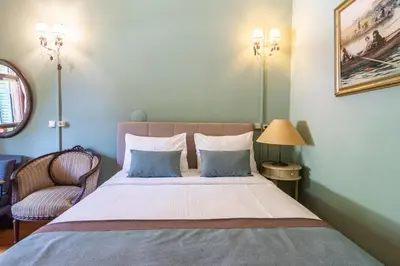 a bedroom with a bed with two pillows and a chair at Büyükada Anastasia Meziki History Mansion in Buyukada