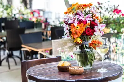 a vase of flowers and a glass of wine on a table at Büyükada Anastasia Meziki History Mansion in Buyukada