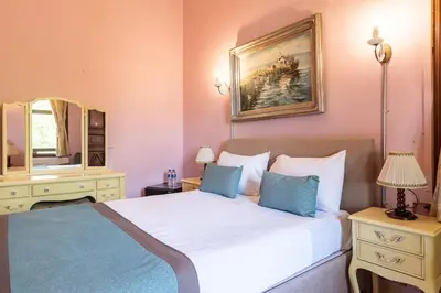 a bedroom with a large bed and a mirror at Büyükada Anastasia Meziki History Mansion in Buyukada