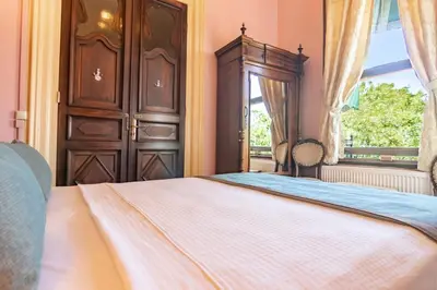 a bedroom with a large bed and a window at Büyükada Anastasia Meziki History Mansion in Buyukada