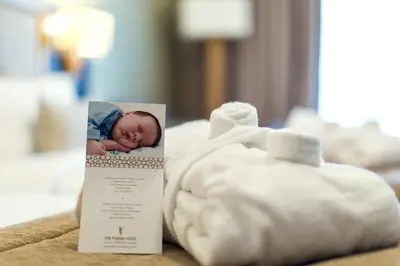 a picture of a baby sleeping on a bed next to towels at The Parma Hotel & Spa Taksim in Istanbul
