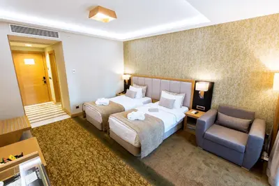 a hotel room with two beds and a chair at The Parma Hotel & Spa Taksim in Istanbul