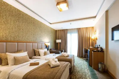 a hotel room with two beds and a desk at The Parma Hotel & Spa Taksim in Istanbul