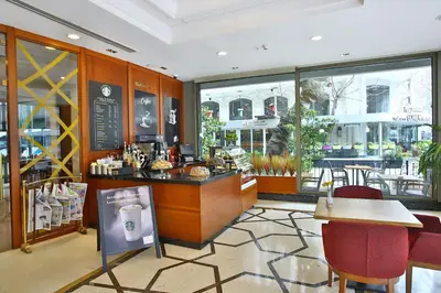 a restaurant with a counter and tables and chairs at The Parma Hotel & Spa Taksim in Istanbul