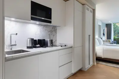 a white kitchen with a sink and a bedroom at Marriott Executive Apartments Istanbul Fulya in Istanbul