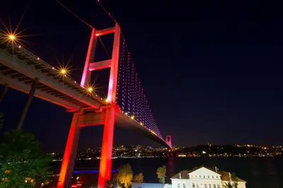 a red bridge with lights on it at night at White Suites Hotel İstanbul in Istanbul