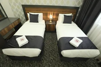 two twin beds in a hotel room withskirtspectspectssenalsenal at El Emin İstanbul Hotel in Istanbul