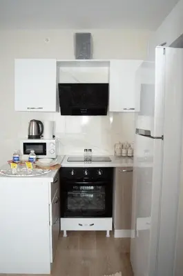 a kitchen with white cabinets and a black oven at Two Bedroom King Suite BH46 in Esenyurt