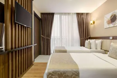 a hotel room with two beds and a flat screen tv at Trademark Collection By Wyndham Operla İstanbul Airport Hotels & Spa in Arnavutköy