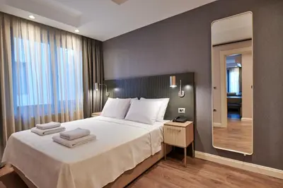 a bedroom with a large bed and a mirror at Livinton İstanbul Ataşehir in Istanbul