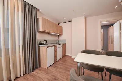 a kitchen and a living room with a table and chairs at Livinton İstanbul Ataşehir in Istanbul