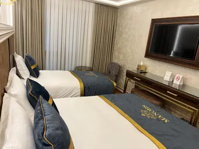 a hotel room with two beds and a flat screen tv at MANORS HOTEL in Istanbul