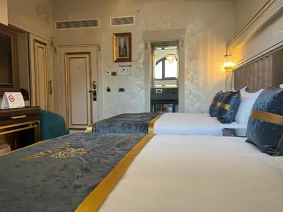 a hotel room with two beds and a desk at MANORS HOTEL in Istanbul