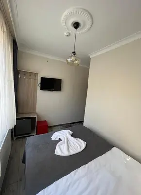a bedroom with a bed with a white robe on it at Oren Hotel in Istanbul