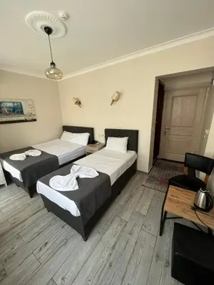 a bedroom with two beds and a table and a chair at Oren Hotel in Istanbul