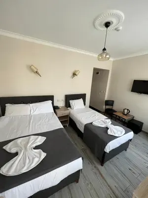 a hotel room with two beds and two tables at Oren Hotel in Istanbul