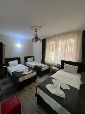 a hotel room with three beds and a ceiling at Oren Hotel in Istanbul
