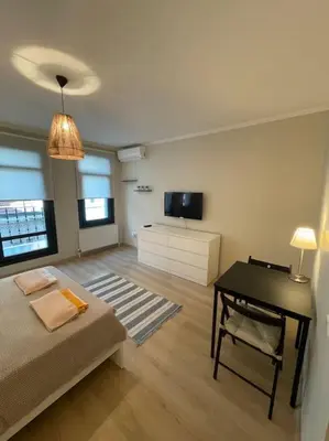 a room with a bed and a desk and a television at Apt w/ Balcony in center,5 mn walk to Istiklal in Istanbul