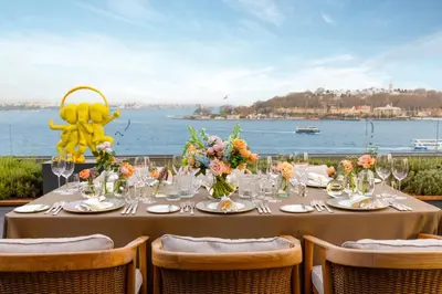 a dining table with a view of the water at The Peninsula Istanbul in Istanbul