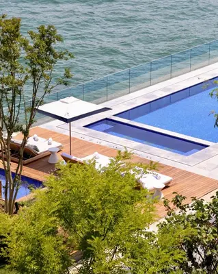 a swimming pool with two lounge chairs and an umbrella at The Peninsula Istanbul in Istanbul