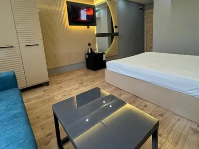 a room with a bed and a couch and a tv at Asem Palace in Istanbul