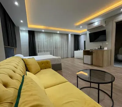 a living room with a yellow couch and a television at Asem Palace in Istanbul