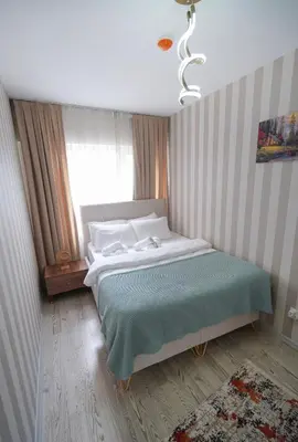 a bedroom with a bed with a green blanket and a window at Luxe Suite HA8 in Esenyurt