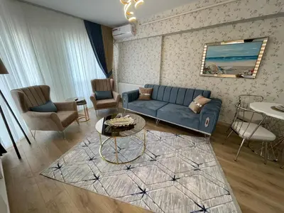 a living room with a blue couch and chairs at King Suite OK0 in Esenyurt