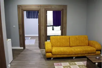 a living room with a yellow couch and a bedroom at biglife hotel in Istanbul