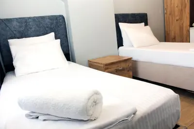 two beds in a room with white sheets at biglife hotel in Istanbul